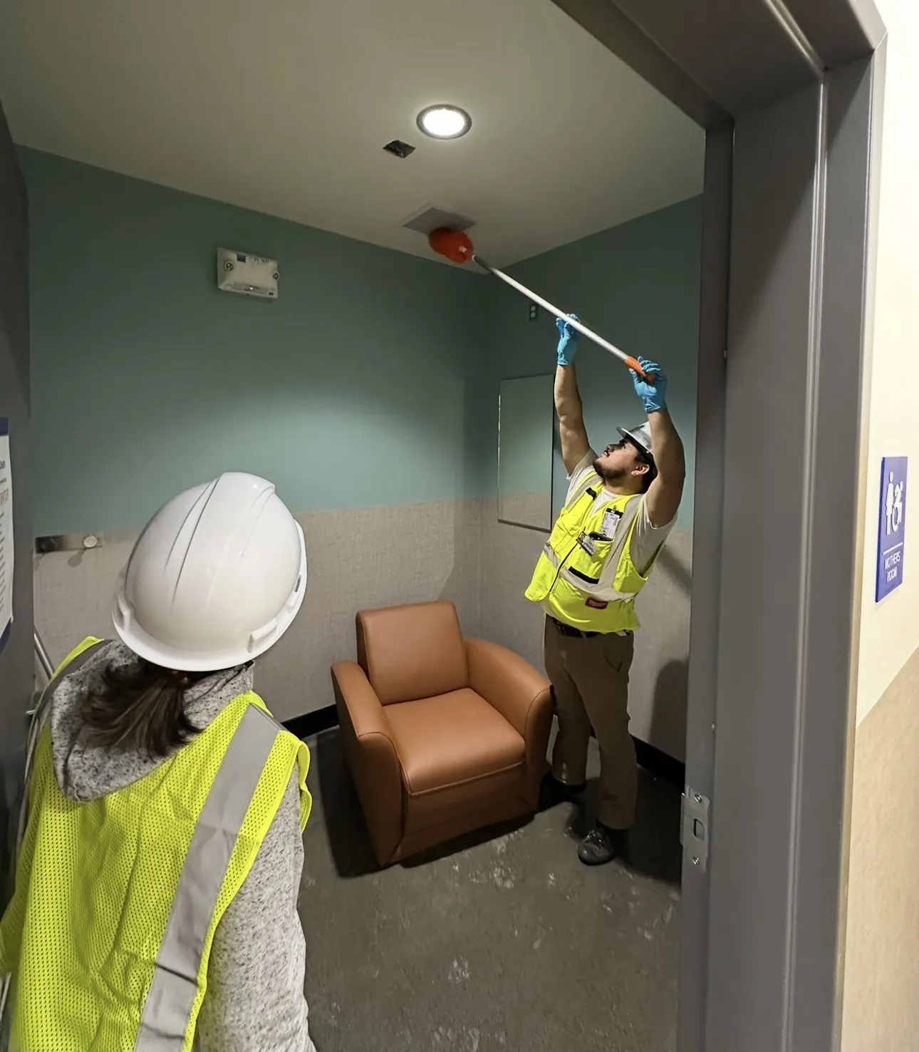J&A crew dusting high surfaces after construction