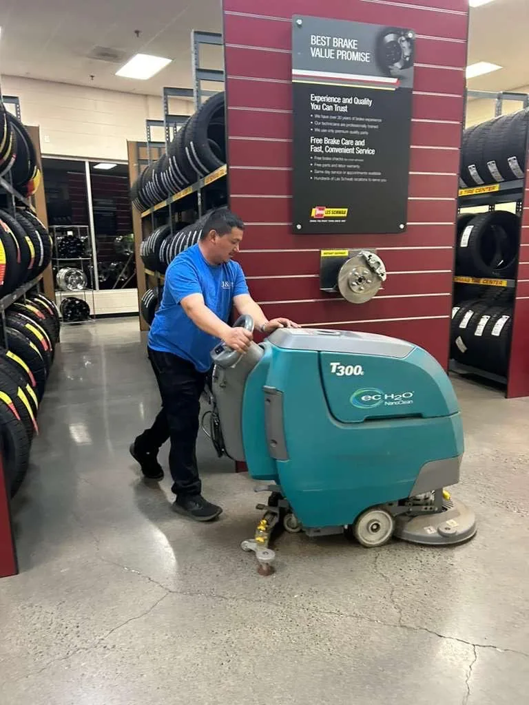 J&A team member operating a commercial floor scrubber